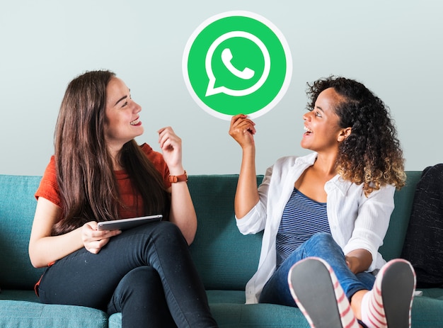 Bezpłatne zdjęcie młode kobiety pokazujące ikonę programu whatsapp messenger