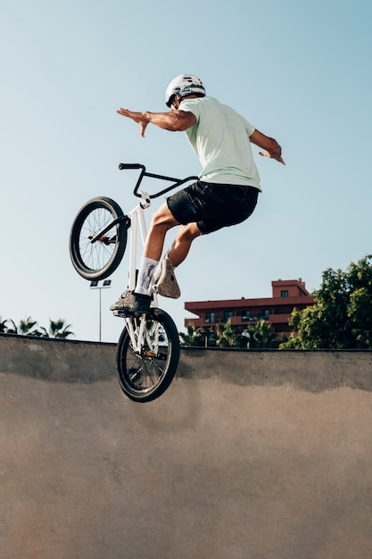 Bezpłatne zdjęcie młody człowiek, jazda na rowerze bmx w skateparku