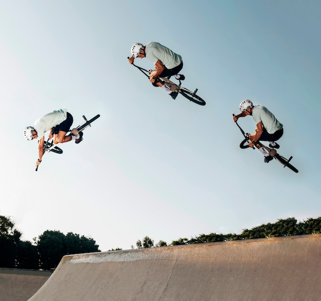 Młody człowiek skoki z rowerem BMX w skate parku