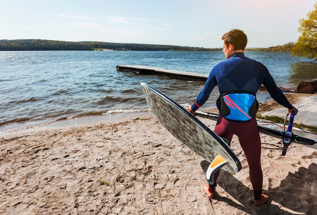 Bezpłatne zdjęcie młody człowiek z deską kitesurfingu