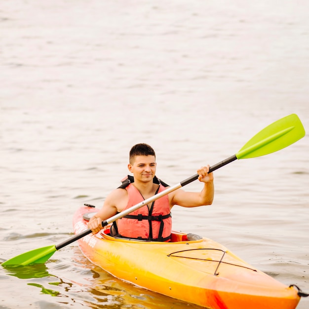 Bezpłatne zdjęcie młody męski kajakarz kayaking na jeziorze