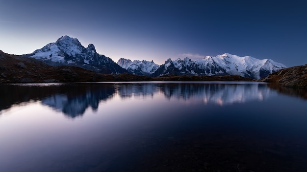 Bezpłatny plik Zdjęcie mont blanc pokryta śniegiem odbijającym się w wodzie wieczorem w chamonix we francji