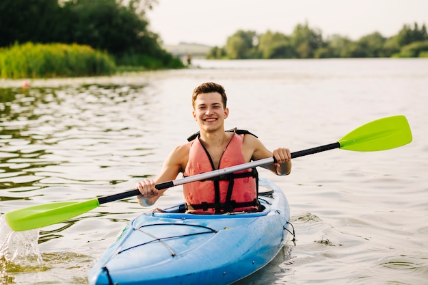 Bezpłatne zdjęcie obsługuje obsiadanie w kajaku używać paddle na jeziorze