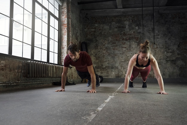 Pełny strzał sportowców wykonujących burpees w środku