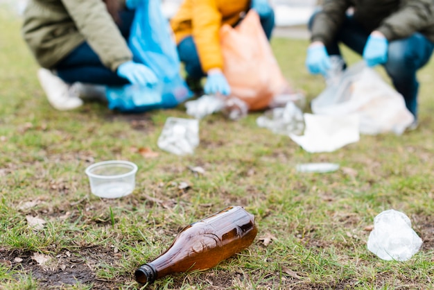 Bezpłatne zdjęcie plastikowa butelka na ziemi z rozmytymi dziećmi