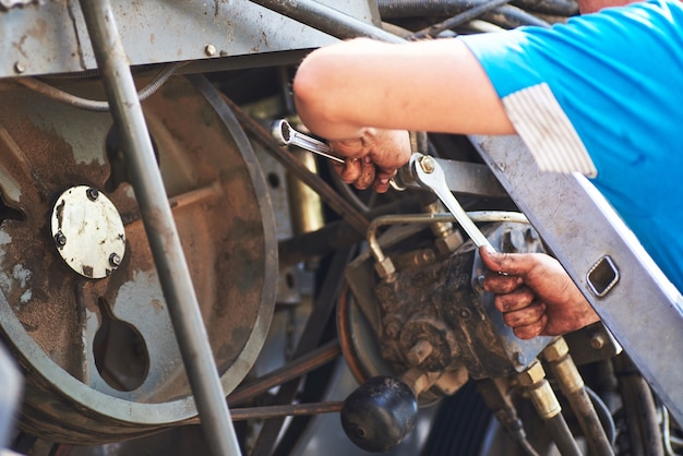 Bezpłatne zdjęcie połącz serwis maszyn, mechanik naprawiający silnik na zewnątrz.