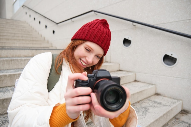 Bezpłatne zdjęcie portret fotografki spacerującej po mieście z profesjonalnym aparatem robiącym zdjęcia capturi