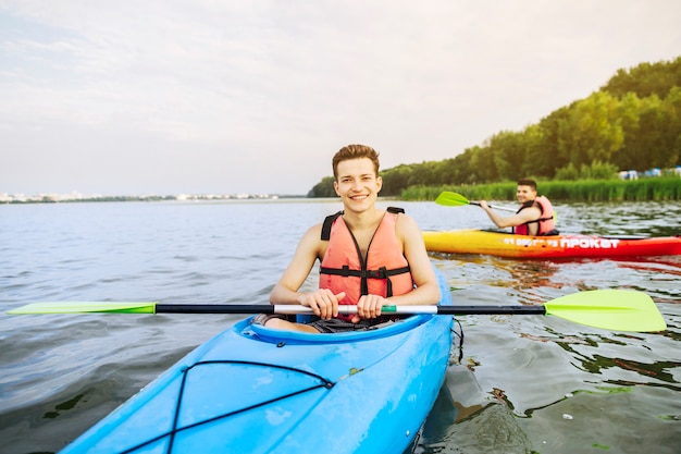 Bezpłatne zdjęcie portret uśmiechnięty męski kajakarz kayaking na jeziorze