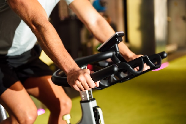 Bezpłatne zdjęcie ręki mężczyzna szkolenie przy gym robi cyclo salowemu.