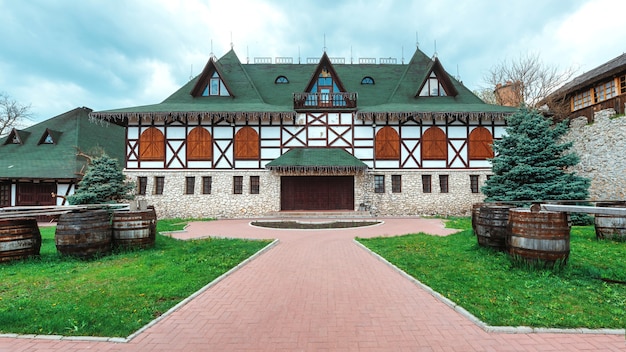 Bezpłatne zdjęcie stary dom wykonany w narodowym stylu rumuńskim. zielone podwórko na pierwszym planie