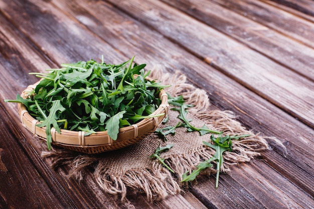 Bezpłatny plik Zdjęcie świeża żywność, zdrowe życie. zielony arugula słuzyć w pucharze na nieociosanym tle