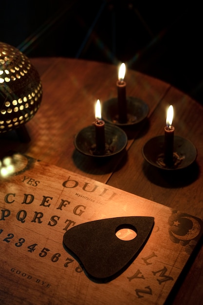 Bezpłatne zdjęcie tablica ouija i układ świec pod wysokim kątem