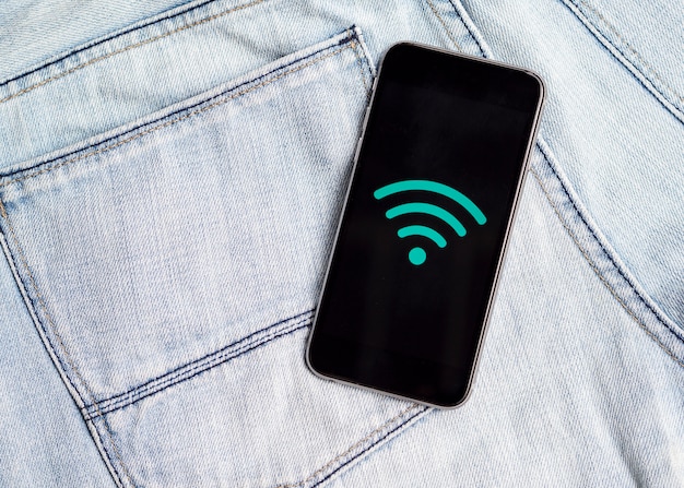 Bezpłatne zdjęcie telefon z symbolem wi-fi na dżinsach