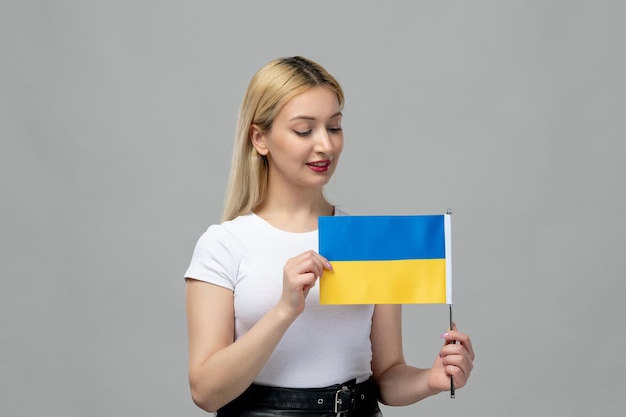 Ukraina rosyjski konflikt blondynka urocza dziewczyna z czerwoną szminką i ukraińską flagą patrzącą na flagę