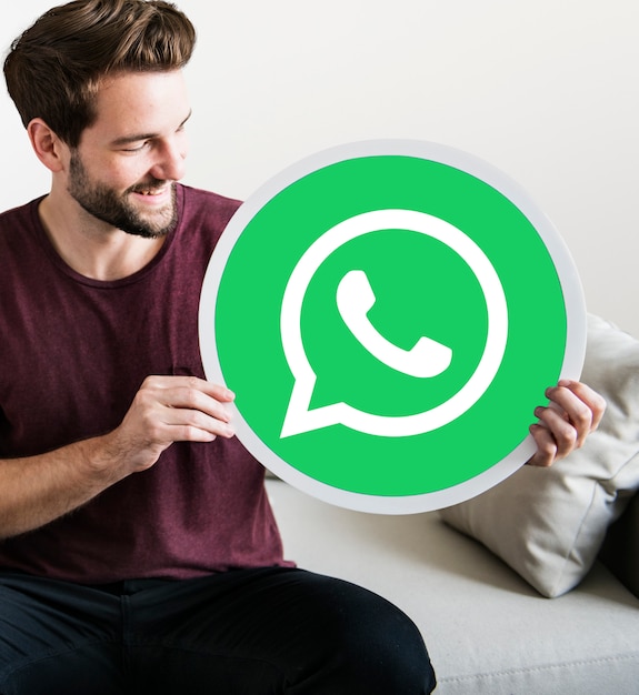 Bezpłatne zdjęcie wesoły człowiek posiadający ikonę whatsapp messenger