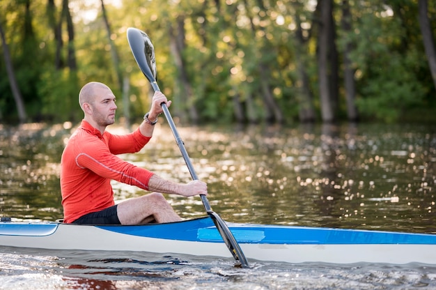 Bezpłatne zdjęcie widok z boku człowieka w canoe z wiosła