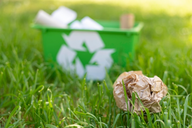 Bezpłatne zdjęcie widok z przodu recyklingu kosz na trawie z śmieci