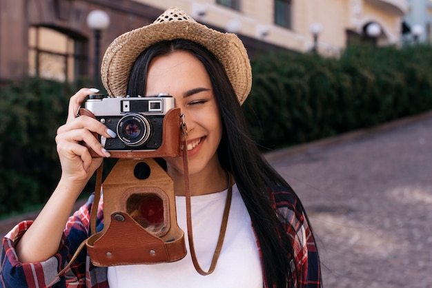 Zakończenie szczęśliwa młoda kobieta bierze fotografię z kamerą przy outdoors