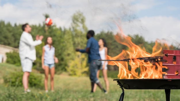 Foto gratuito amici che giocano con la palla accanto al barbecue