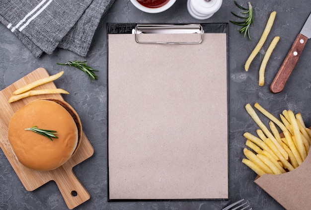 Foto gratuito appunti accanto a hamburger e patatine fritte