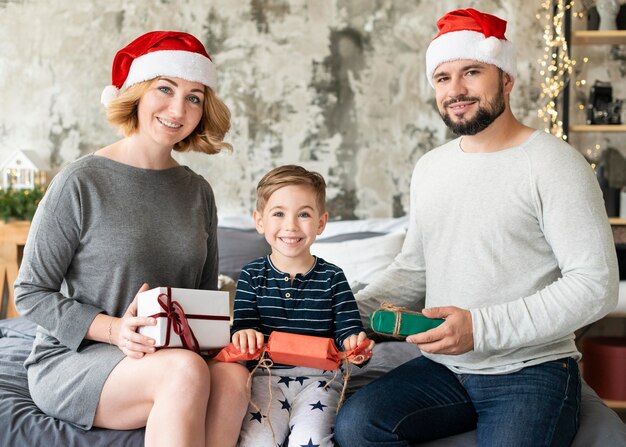 Bambino e genitori di vista frontale che stanno insieme il giorno di Natale