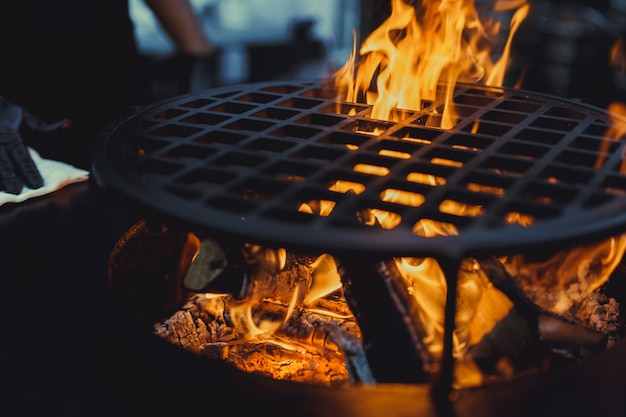 Foto gratuito barbecue, primo piano. cucinando professionalmente il cibo su un fuoco aperto su una griglia in ghisa.