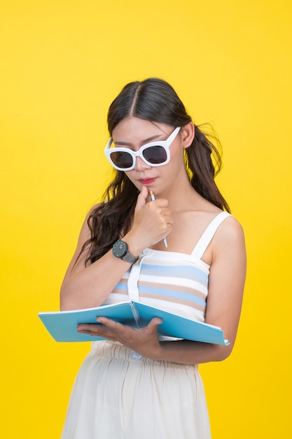 Foto gratuito belle studentesse tengono quaderni e penne