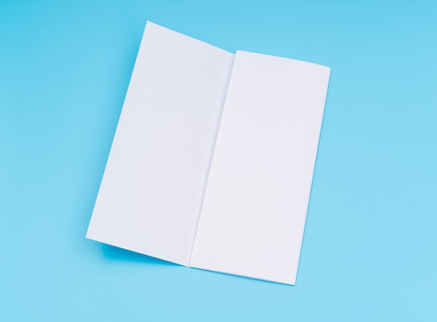 Carta di modello bianco trifold su sfondo blu.