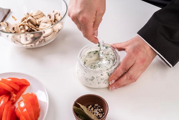 Foto gratuito chef mescolando salsa con funghi e pomodori