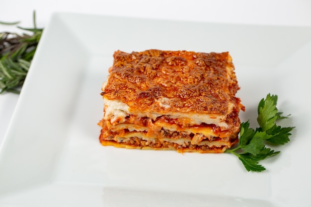 Foto gratuito colpo del primo piano di lasagne su un piatto bianco