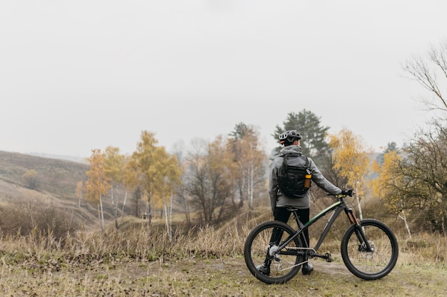 Foto gratuito colpo lungo dell'uomo che guida una bicicletta