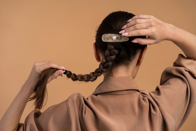 Foto gratuito donna di vista posteriore che porta grande fermaglio per capelli