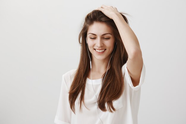 Donna felice sorridente che gode dell'ascolto della musica in auricolari