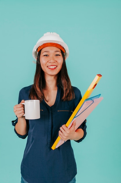 Foto gratuito draftswoman asiatica sorridente con la bevanda calda