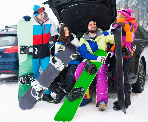 Due coppie che si divertono e fanno snowboard