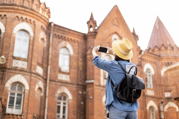 Foto gratuito elegante viaggiatore con cappello scattare foto in vacanza