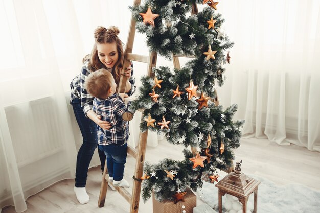 Famiglia sveglia che si siede vicino all&#39;albero di Natale