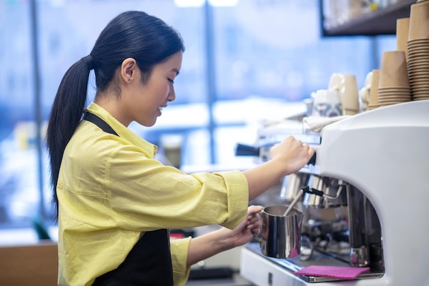 Foto gratuito fare il caffè. barista che prepara il caffè e mescola il latte