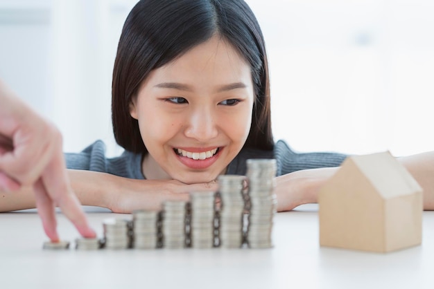 Foto gratuito felicità donna asiatica mano con il concetto di idee di affari finanziari pila di monete