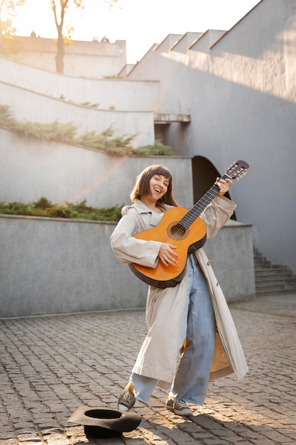 Giovane donna che suona la chitarra all'aperto