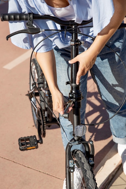 Foto gratuito giovane donna che usa la sua bicicletta pieghevole