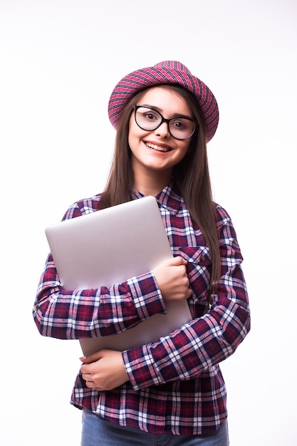 Giovane donna fiduciosa sorridente utilizzando il computer portatile e guardando la fotocamera isolata su sfondo bianco