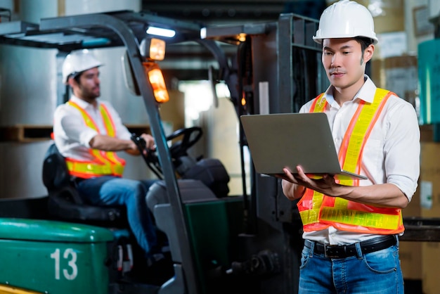 Foto gratuito ingegnere personale magazziniere maschio in elmetto che lavora a piedi attraverso il centro logistico magazzino fabbrica cantiere logistica architetto forklife driver uomo costruttore interni sfondo