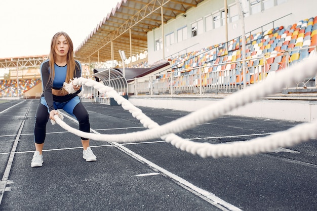 Foto gratuito mette in mostra la ragazza in un addestramento uniforme blu allo stadio con la corda