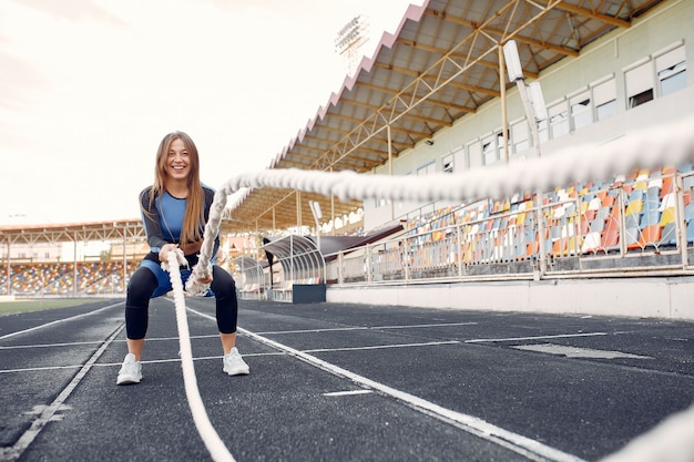 Foto gratuito mette in mostra la ragazza in un addestramento uniforme blu allo stadio con la corda