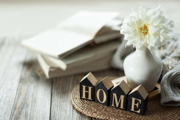 Foto gratuito natura morta con l'iscrizione casa e un fiore bianco