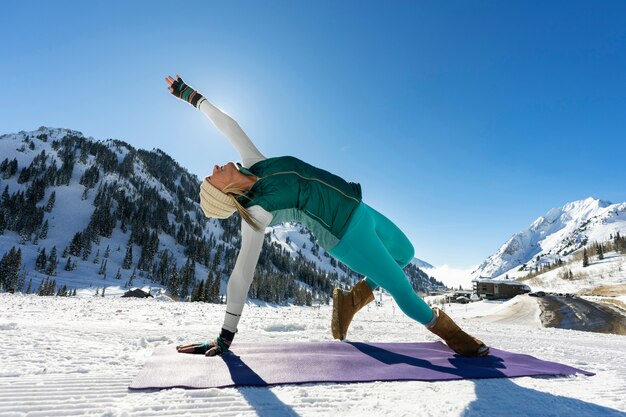 Persona che fa yoga in tempo freddo e invernale