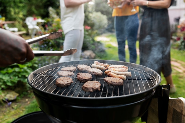 Persone di vista laterale che chiacchierano vicino al barbecue