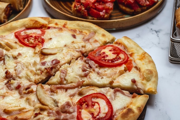 Foto gratuito pizza con la vista laterale dei funghi del formaggio del pomodoro del pollo