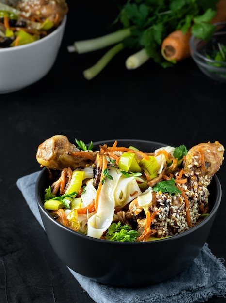 Pranzo in stile asiatico con noodles con pollo in salsa teriyaki, verdure, spezie e microgreens